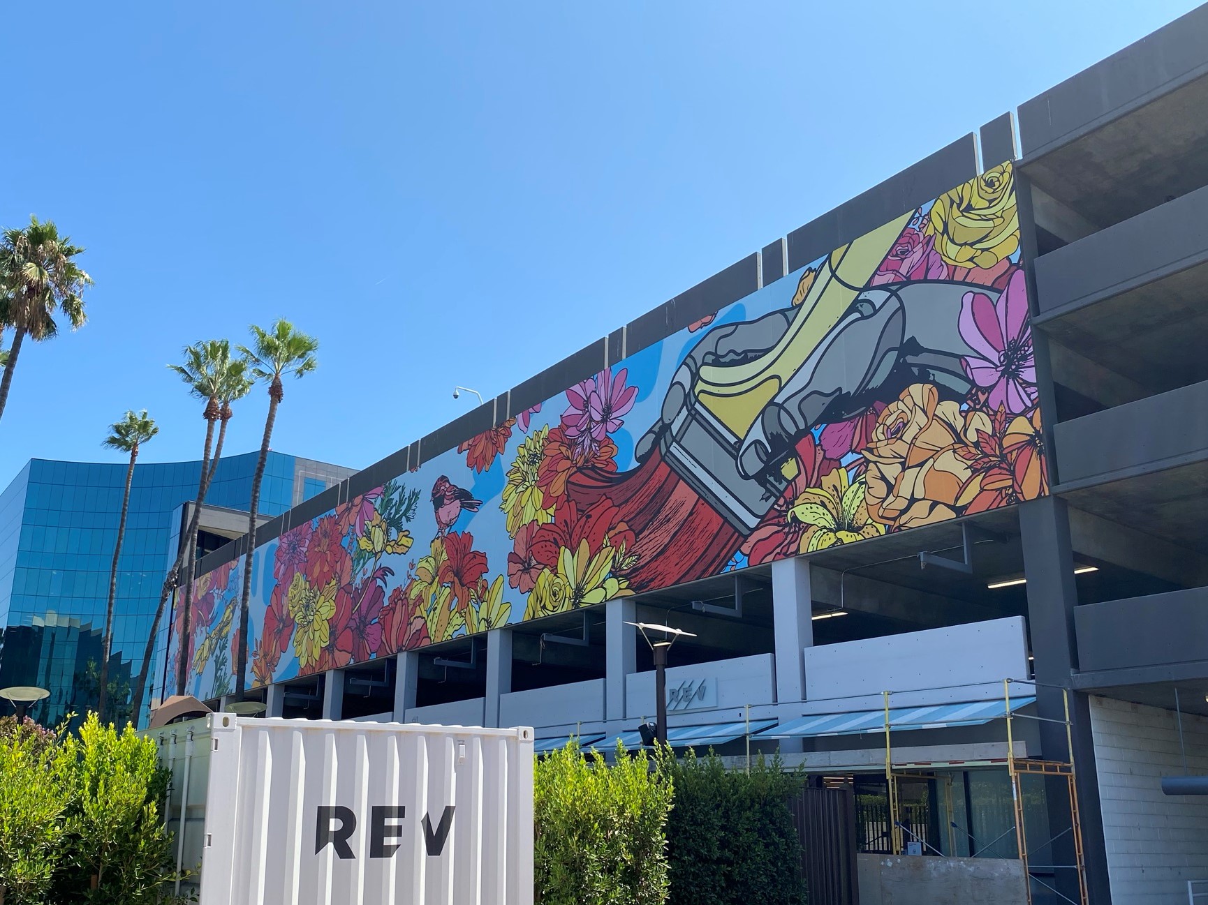 Mural with flowers and a roller skate on parking garage.