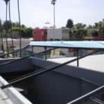 Solar water heater panel on rooftop with metal supports.