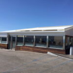 Modern single-story building with large windows and slanted roof.
