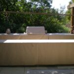 Patio furniture and a grill with protective covers.
