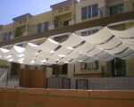 Fabric shade sails in wave pattern above courtyard.