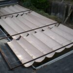 Retractable fabric canopy over patio with metal frame and cables.