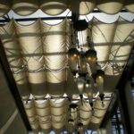 Ceiling draped with sheer fabric and hanging pendant lights.