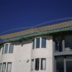 Modern building with large windows and rooftop awning.
