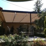 Patio with metal chairs, table, and retractable shade canopy.