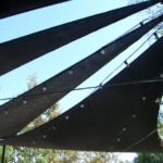 Shade sails with hanging string lights outdoors.