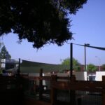 Wooden fence and mesh canopies shading outdoor area.