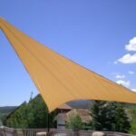 Triangular shade sail installed over outdoor deck.