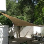 Triangular shade sail over patio dining area.