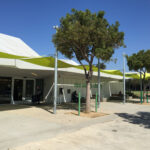 Library building with shade sails and a person at the entrance.