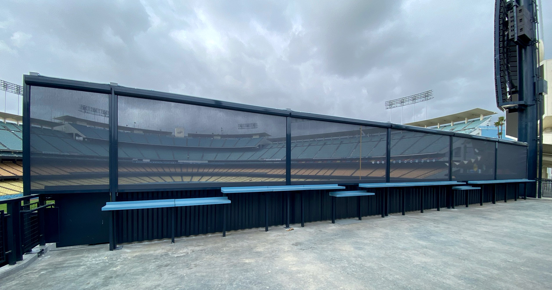 Stadium seating area with countertops and mesh fencing.