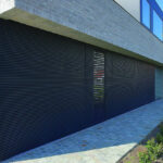 Building with horizontal louvered shutters over windows.