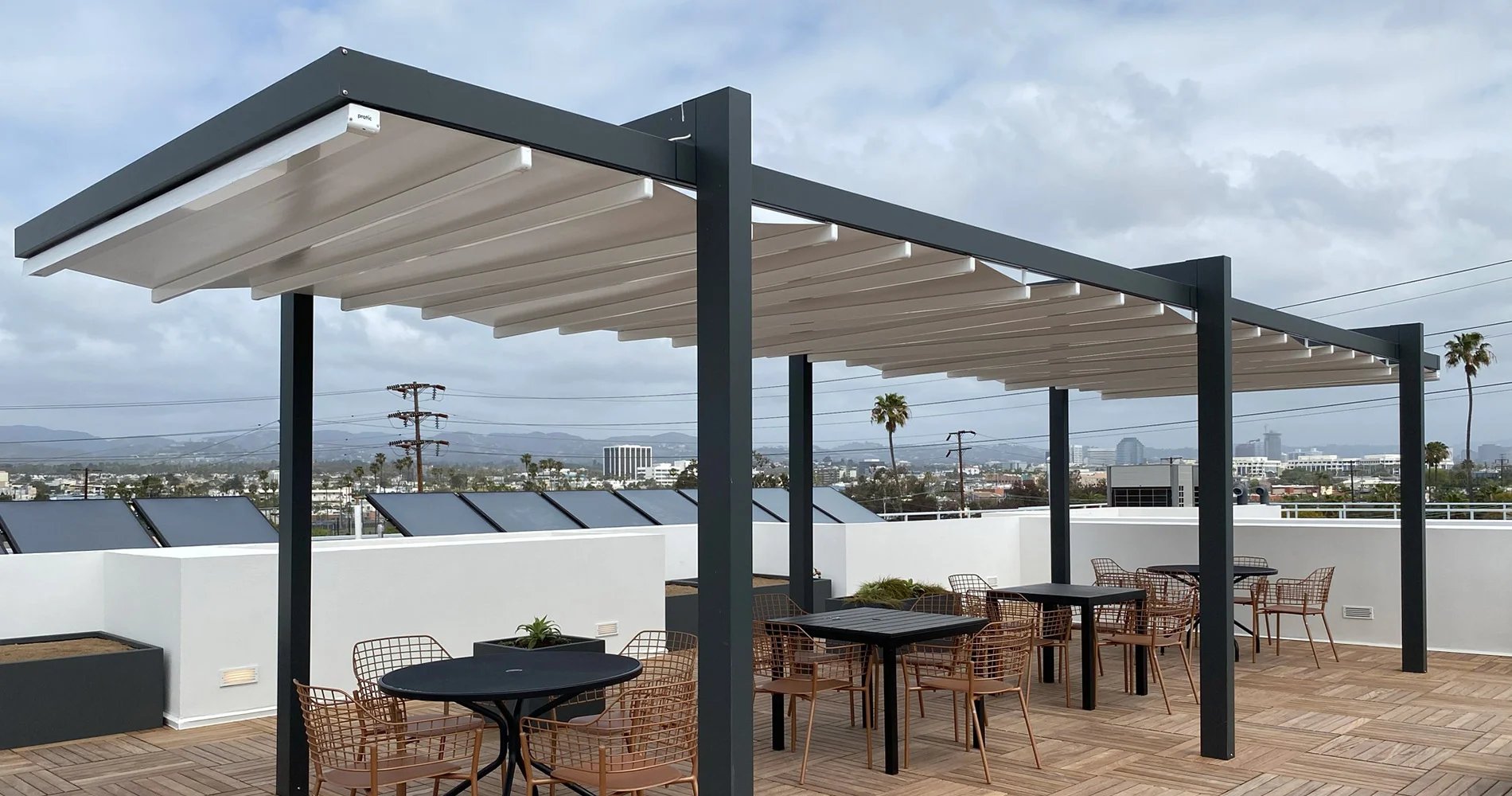 Rooftop patio with pergola, outdoor seating, and wood decking.